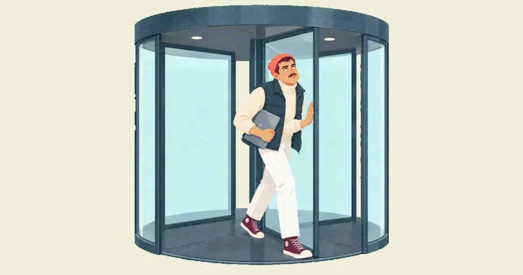 Ivo, laptop under his arm, comes round again in an office revolving door, eyes rolled up in comic exasperation.