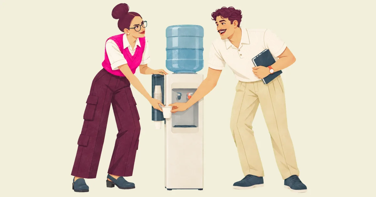Noor and Ivo at an office water cooler both reach for the same paper cup at once, hands meeting on it; Ivo laughs and Noor gives a wry smile.